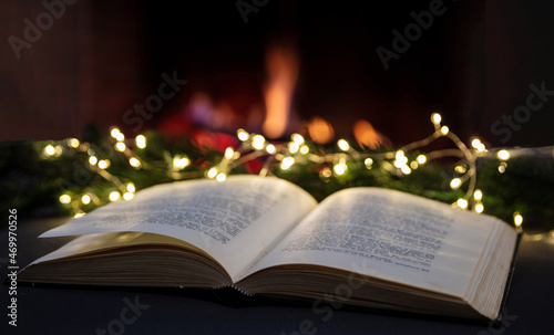 Christmas reading and relaxing by the fire, Book open, xmas tree lights, fireplace burning