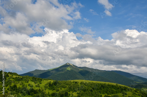 Beautiful landscape of green mountains  grassy field and rolling hills with cloudy blue sky. Carpathians  Ukraine