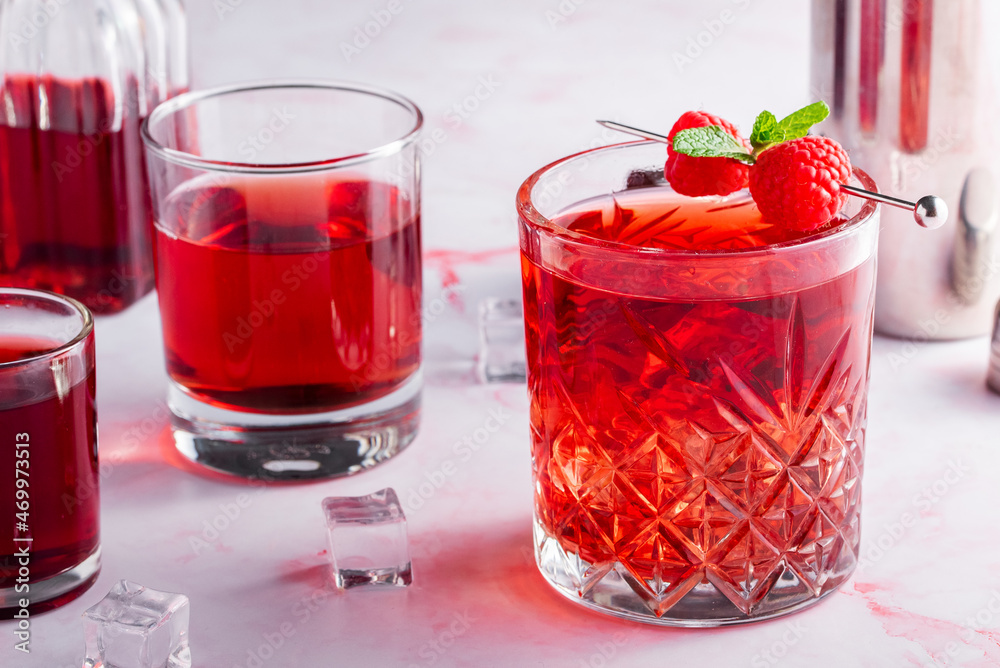 red cocktail with raspberries on a pink background red cocktail with raspberries on a pink background