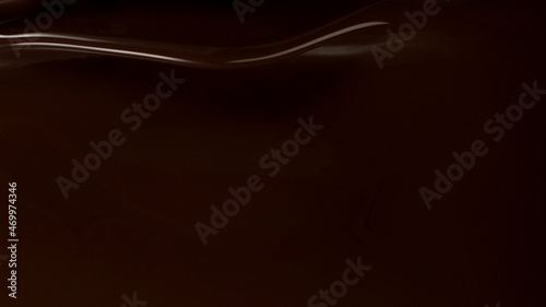 Closeup of splashing dark melted chocolate