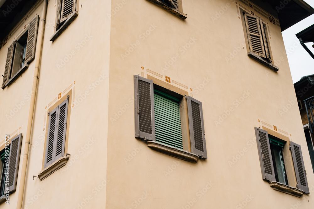 Facade of an old house with shutters on the windows in the town of Varenna