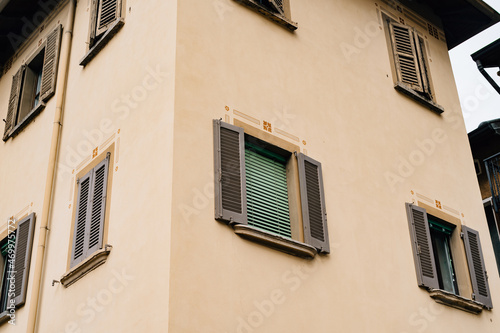 Facade of an old house with shutters on the windows in the town of Varenna © Nadtochiy