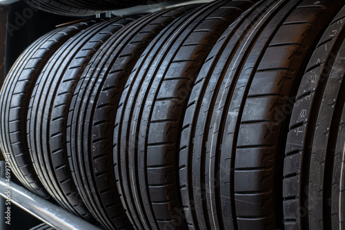 Close up new tyres on shelve in tire shop. Car tires on rack in auto store.