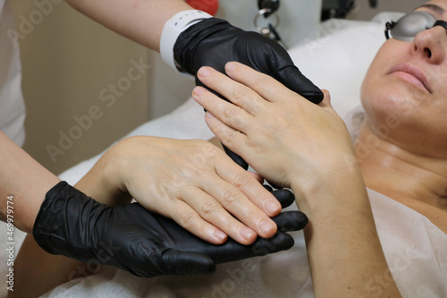 Doctor beautician examines the hands of the patient