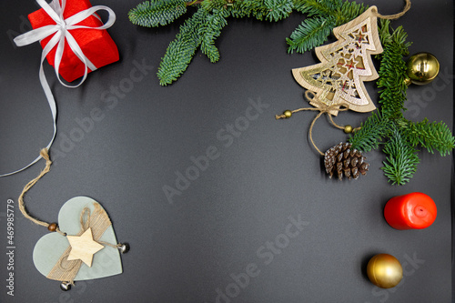 New Year's background. Christmas decorations and fir branches on a black background. Top view.