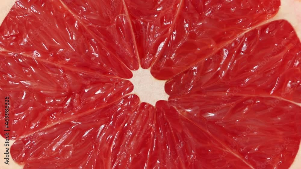 Grapefruit, citrus fruit cut in middle rotating, close-up macro, top view.