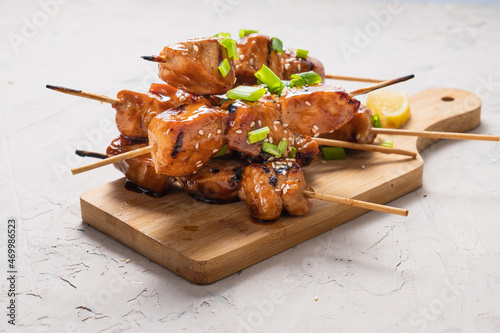 Chicken fillet yakitori on a white table. Appetizing slices of fried chicken on skewers. photo