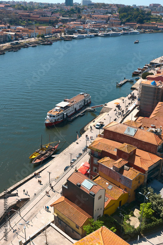 top view of a cruise liner and a vintage boats for transporting port wine on the Douro river in the Portuguese city of Porto