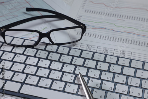 business and finance concept. Glasses, keyboard, notebook, charts and receipts, business setting