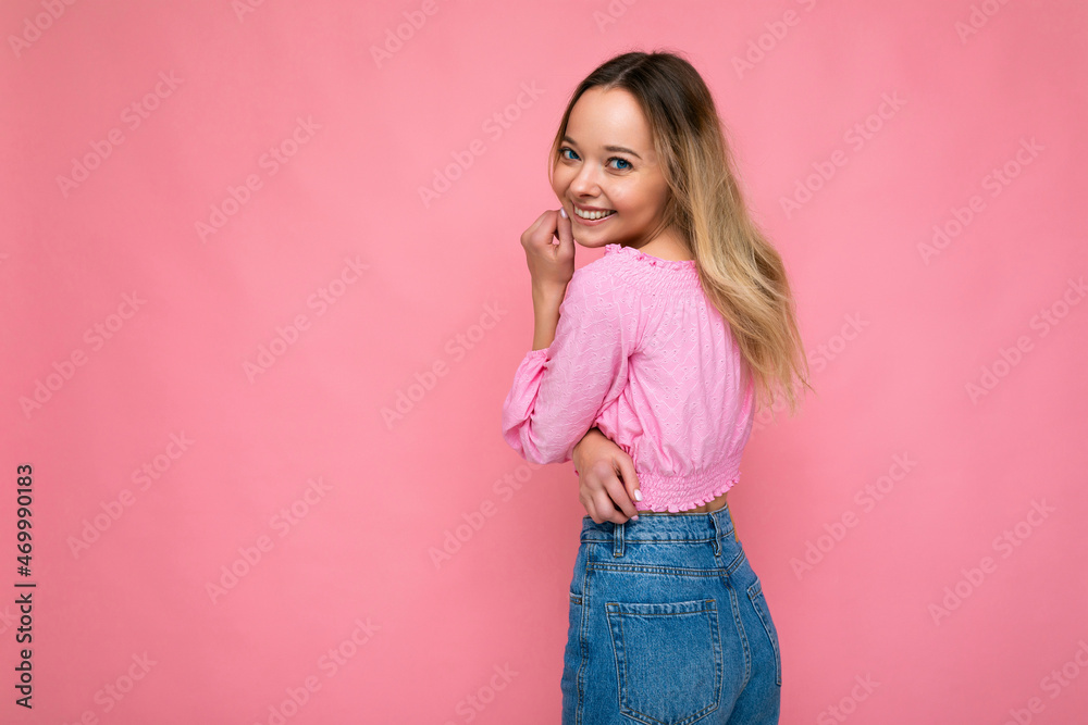 Young beautiful woman. Trendy woman in fashionable pink crop top. Positive female shows facial emotions. Funny model isolated on pink background with free space Young beautiful woman. Trendy woman in fashionable pink crop top. Positive female shows facial emotions. Funny model isolated on pink background with free space