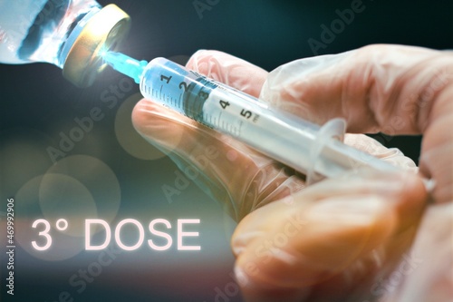 Doctor wearing latex glove in a lab while preparing an injection with the text "3° dose"