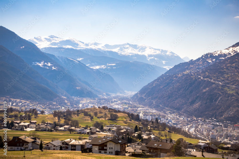 Fototapeta premium Green valley with some houses between the snowed mountains in center Switzerland, Europe 