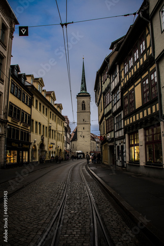 Street with a rail and a church at the background in a dark mood. Erfurt, Germany 