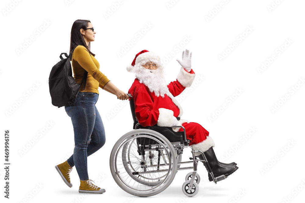 Female student walking and pushing cheerful santa claus in a wheelchair