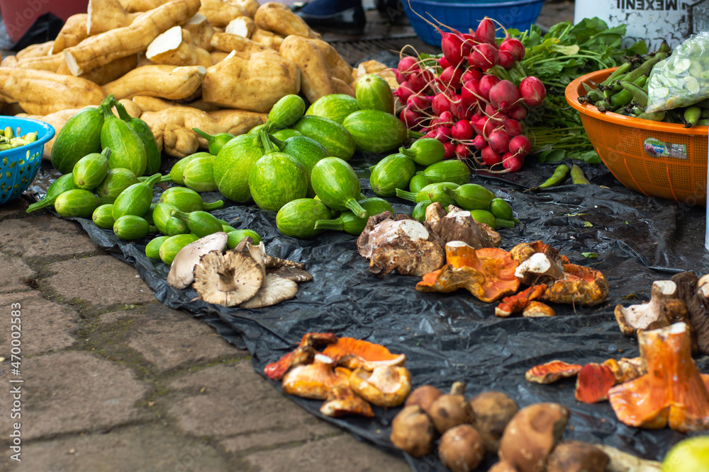 Vegetables and mushrooms on a tarpaulin at a street market