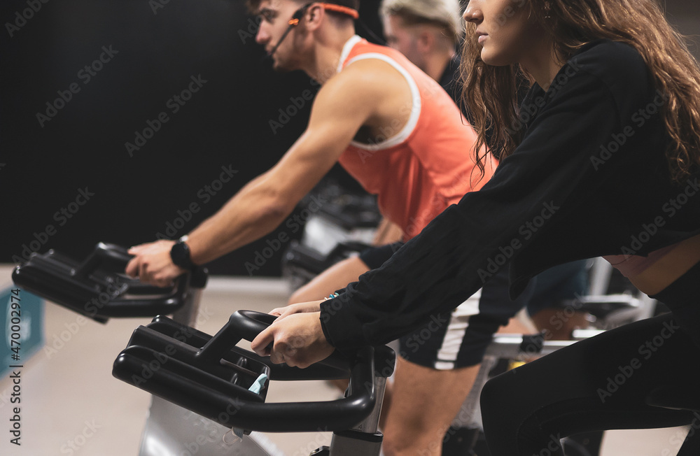 3 young people giving an exercise bike class in a gym. 3 young people giving an exercise bike class in a gym.