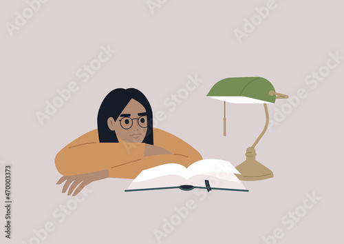 A young female Caucasian character leaning on arms and reading a book, educational process, a university student preparing for the exams in the library