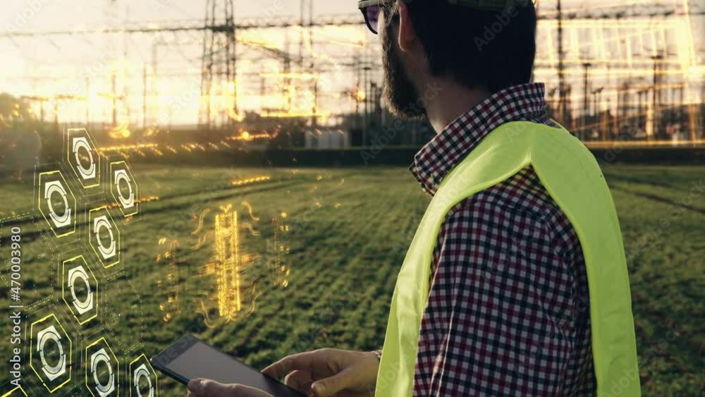 Electric engineer wearing helmet safety vest working with tablet near high voltage lines power station holographic energy animation during sunset shot in 4k super slow motion