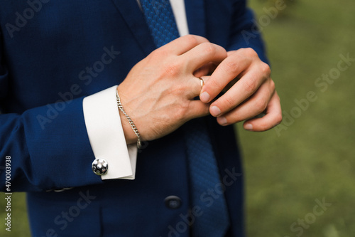 close-up of the groom straightens the ring on his hand
