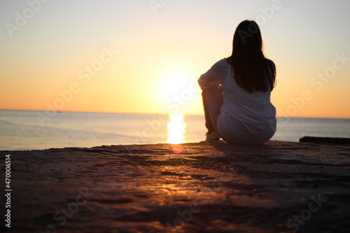 Pre-war times in Ukraine. Good morning. The girl looks at the calm of the sea. Quiet and lonely.