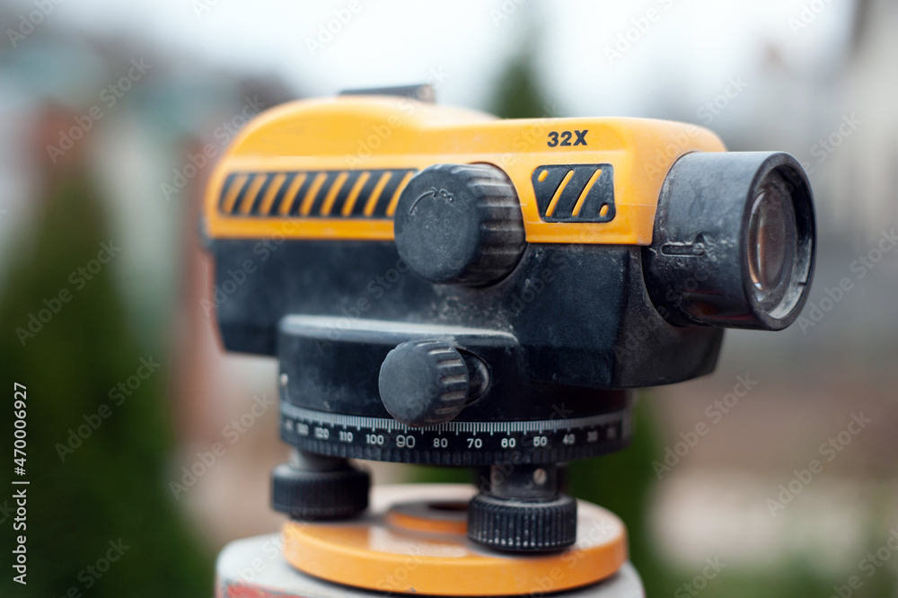 Surveying measuring equipment level transit on tripod at construction building area site