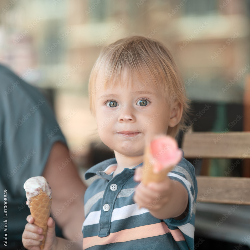 Child holds icecream and shares with others Child holds icecream and shares with others