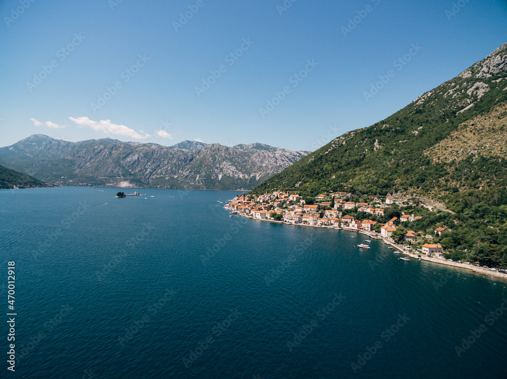 Drone view of the Perast coast at the foot of the green mountain. Montenegro