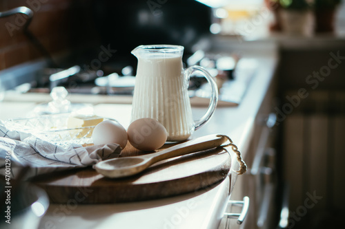 Fresh milk and eggs on wooden board in real home kitchen interior with natural light © Daria Minaeva