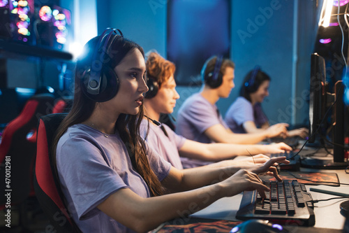 Gamers in gaming headsets playing in strategy video games on the computers