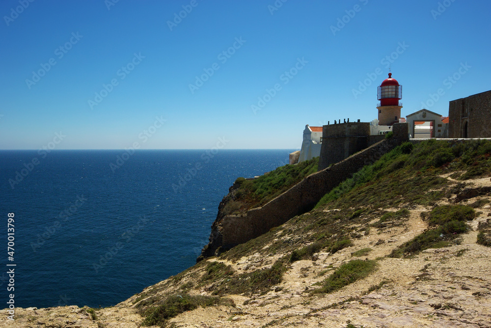 Lighthouse at Sant Vincent cape, with calm blue ocean at the background