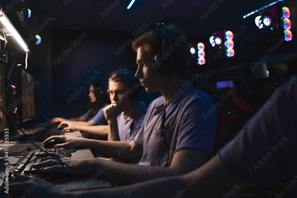 Young professional gamer playing online video games on his PC