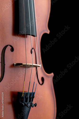 A part of a wooden violin or viola on a black background