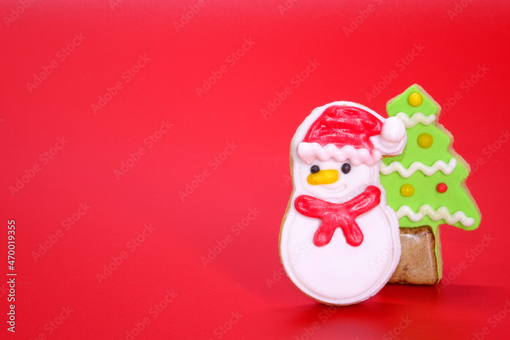 Christmas cookies on red background, Christmas greeting card with cute snowman and colorful Christmas tree cookies on red background, copy space. Xmas 