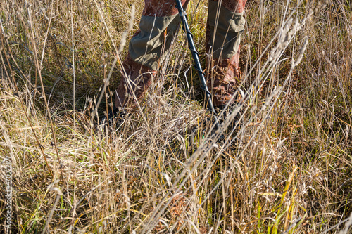 A man with a metal detector. Look for metal in the woods. Precious search engine.