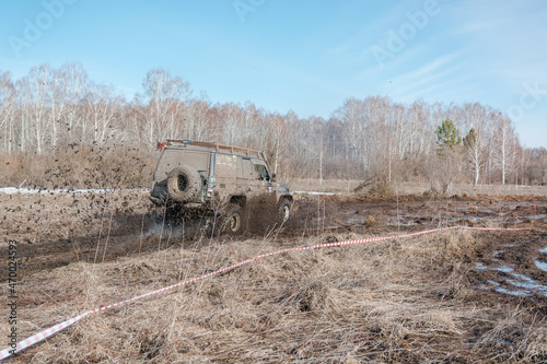 Zarinsk, Russia -April 15, 2017: cars drive through the mud in the spring. Cars go through the swamp. Men are pushing cars