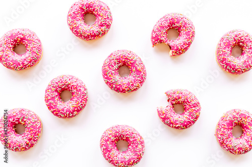 Pink frosted donuts with colorful sprinkles. Bakery background