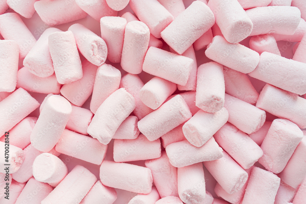 Lots of pink marshmallows are scattered over the surface. Close up. Selective focus. Lots of pink marshmallows are scattered over the surface. Close up. Selective focus.