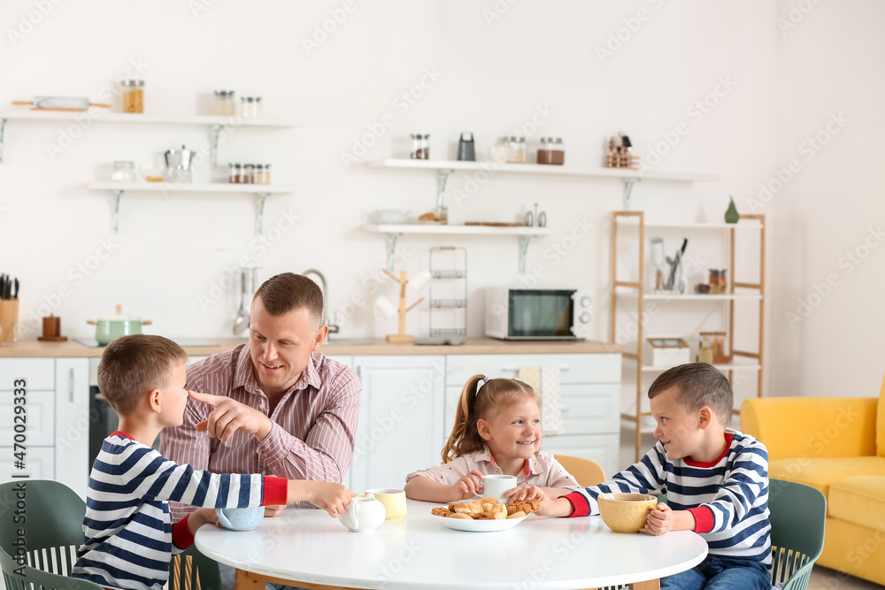 Happy father with his little children spending time together at home