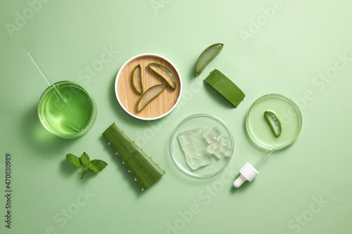 Aloe vera extract research in laboratory with a petri dish dropper in light green background for aloe vera research advertising , photography science content , top view