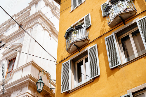 Flowers on the balconies and shutters on the windows of the old house. Bergamo, Italy