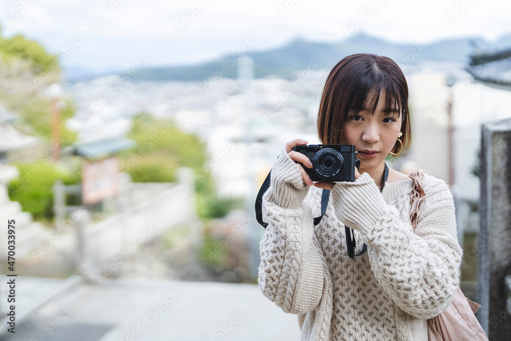 カメラを持って観光地を散策する女性