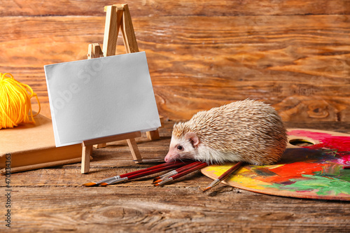 Cute hedgehog with easel an...
