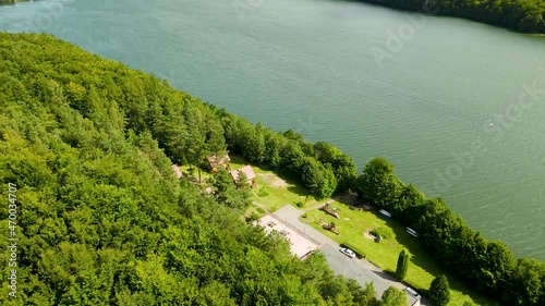 Aerial backwards shot of beautiful natural lake and beautiful forest trees on shore - Raduńskie Dolne Lake,Borucino photo