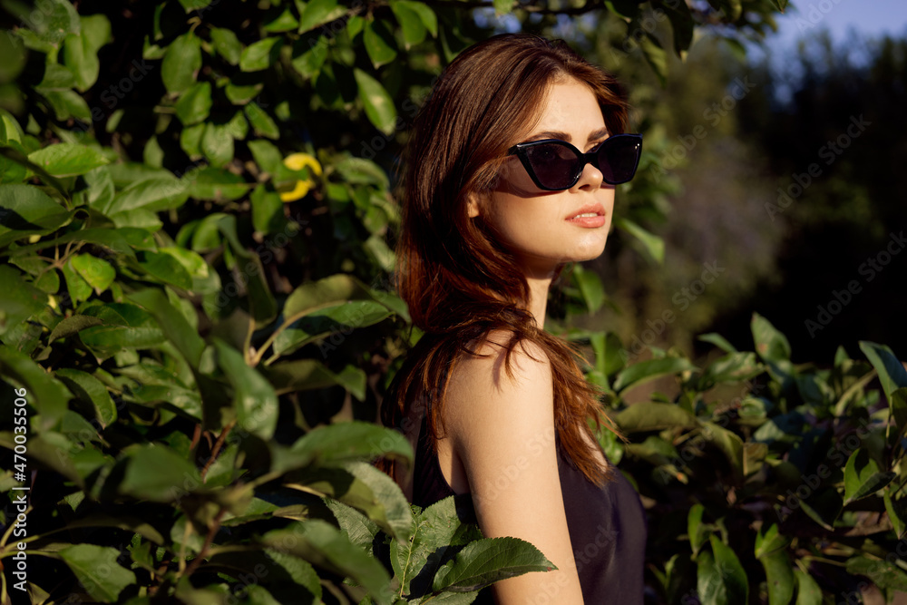 pretty woman in sunglasses in summer outdoors green leaves