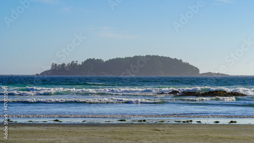 Looking to Pacific Ocean and island, listen to waves at Tofino beach during summer road trip in Vancouver Island