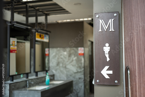 A gentlemen or male icon in front of the public toilet. Sign and symbol object photo. Close-up.