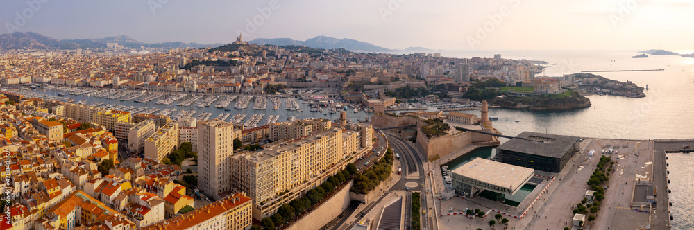Scenic aerial view of coastal area of Marseille overlooking medieval Fort Saint-Jean and Old Port with moored yachts on bank of Gulf of Lion in autumn, France