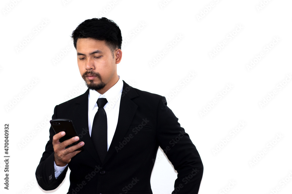 A young businessman in a black suit takes mobile messaging in corporate chats seriously. Empty space for text. White background. A young businessman in a black suit takes mobile messaging in corporate chats seriously. Empty space for text. White background.