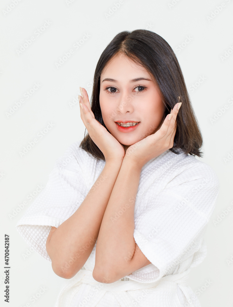 Portrait closeup studio shot of millennial young Asian black short hair female model wearing makeup in shower rope standing smiling look at camera posing holding hands on cheeks on white background Portrait closeup studio shot of millennial young Asian black short hair female model wearing makeup in shower rope standing smiling look at camera posing holding hands on cheeks on white background