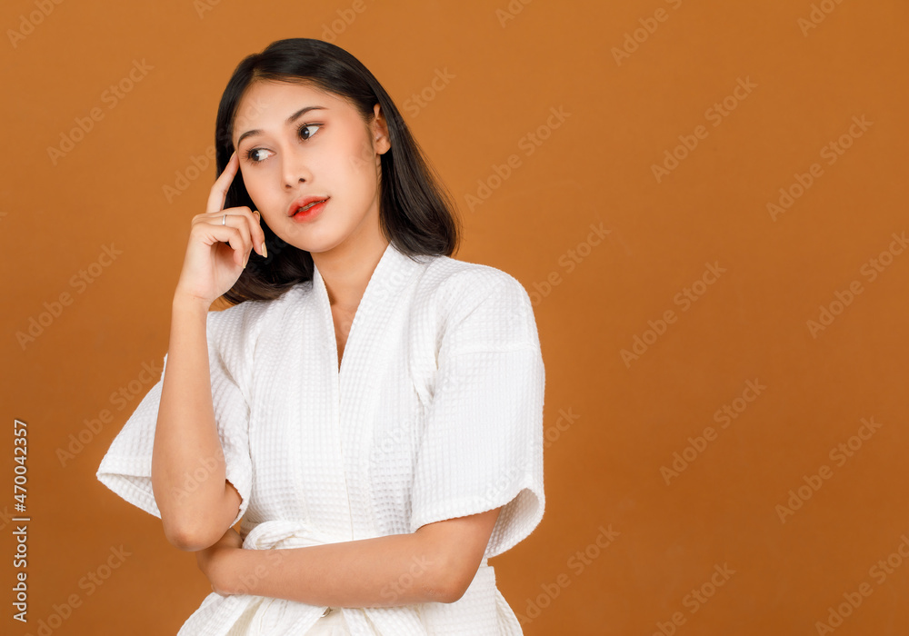 Portrait studio shot of millennial young Asian short black hair female model in white shower rope standing and posing pose in advertising action on brown background Portrait studio shot of millennial young Asian short black hair female model in white shower rope standing and posing pose in advertising action on brown background